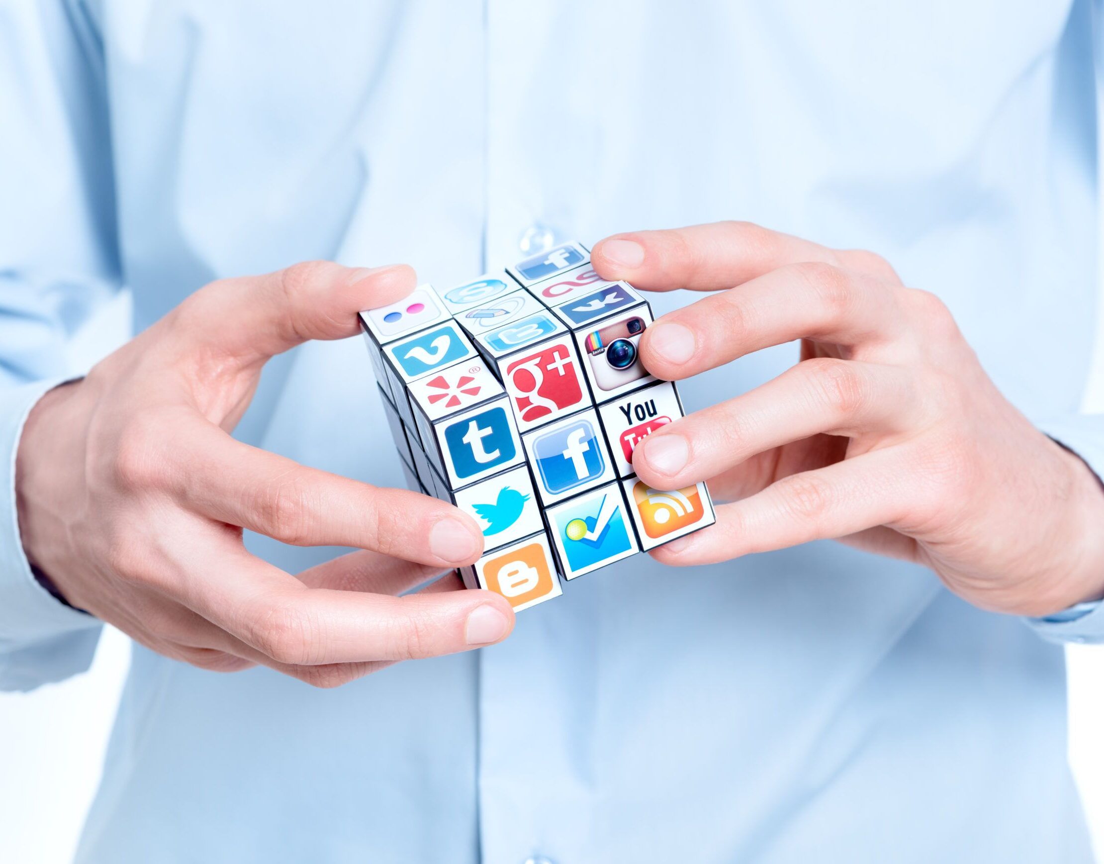 Mann versucht einen Rubiks Cube zu lösen, der mit Logos von Social Media Brands bestückt ist.